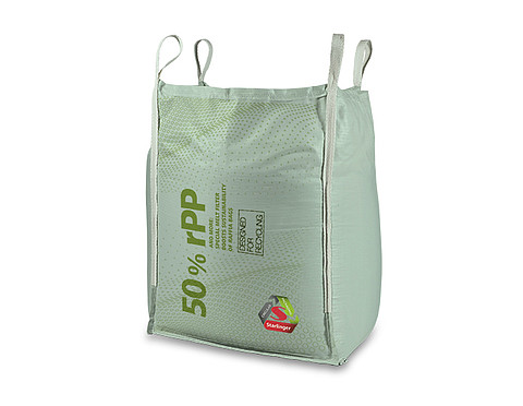 The image shows a 4-loop big bag manufactured on Starlinger machinery. The big bag consists of a high proportion of recycled polypropylene (rPP). On the front of the big bag, the inscription "50% rPP" indicates the percentage of recycled material. Additionally, the inscription "Designed for Recycling" and the Starlinger logo are visible. The big bag is light green in color, with sturdy lifting loops at the four upper corners.